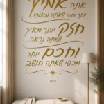 מדבקת קליגרפיה עברית על קיר בסלון עם ספה אפורה ותאורה טבעית