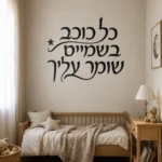 מדבקה עם קליגרפיה עברית וכוכב על קיר בסלון עם ספה לבנה וצמחי בית ירוקים בפינה.