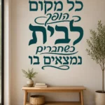 מדבקה עם קליגרפיה עברית על קיר בחדר ילדים עם צעצועים ושולחן כתיבה