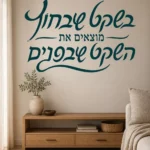 מדבקת קליגרפיה עברית על קיר בסלון עם ספה נוחה ואור טבעי חודר מחלון גדול
