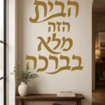 מדבקת קליגרפיה עברית בשחור על קיר בחדר ילדים עם רהיטים צבעוניים
