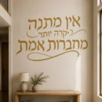 מדבקת קליגרפיה עברית על קיר בסלון עם ספה לבנה ושולחן עץ כהה