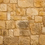 קיר בנוי מלבנים אבן בגוונים של בז' וחום בהיר עם טקסטורה לא סדירה