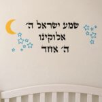 מדבקת ירח סהר צהוב וכוכבים כחולים על קיר חדר ילדים עם מיטה קטנה ושולחן צעצועים