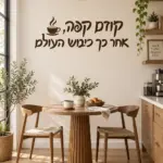 מדבקת קפה שחורה על קיר במטבח עם שולחן עץ וכיסאות לבנים ברקע.