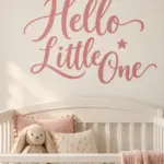 מדבקת 'Hello Little One' על קיר בחדר ילדים עם צעצועים ומיטה קטנה