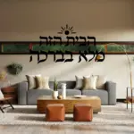 מדבקת טקסט עברי עם שמש על קיר בחדר ילדים עם צעצועים צבעוניים וספרים.