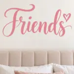 מדבקת 'Friends' בכתב יד שחור עם לב קטן על קיר בחדר ילדים עם צעצועים וספרים על מדף.