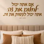 מדבקת טקסט עברי על קיר בסלון עם ספה בהירה ותאורה רכה