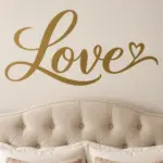 מדבקת המילה Love בכתב יד שחור על קיר בחדר ילדים עם מדף צעצועים וכריות צבעוניות
